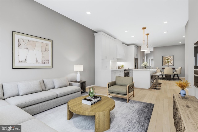 living area featuring light wood-type flooring, baseboards, and recessed lighting