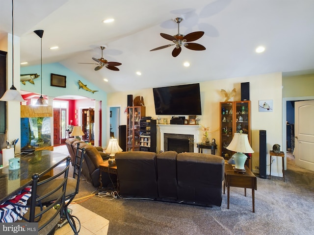 carpeted living room featuring high vaulted ceiling, ceiling fan, and a premium fireplace