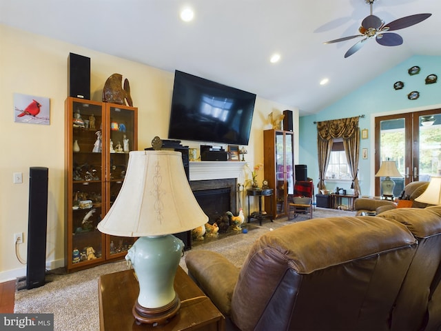 living area featuring carpet, a fireplace, vaulted ceiling, ceiling fan, and baseboards