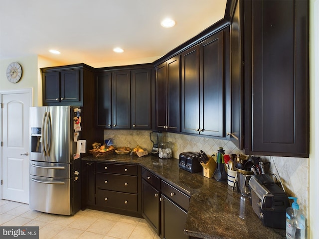 kitchen featuring backsplash, dark stone countertops, stainless steel fridge with ice dispenser, and light tile patterned flooring