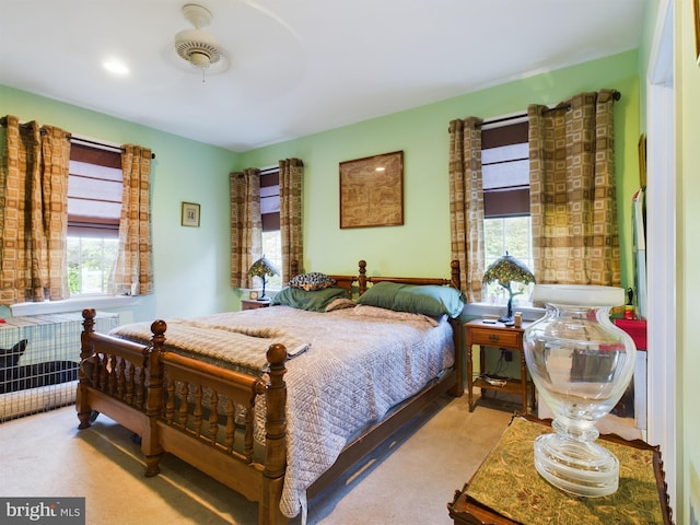 carpeted bedroom with multiple windows and ceiling fan