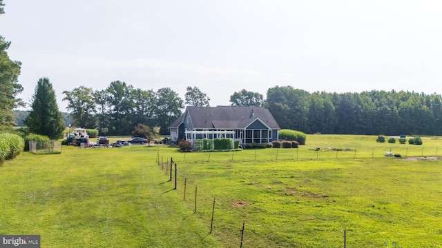 view of yard with fence and a rural view