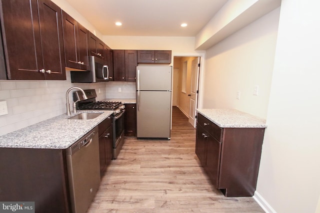 kitchen with decorative backsplash, light hardwood / wood-style flooring, appliances with stainless steel finishes, dark brown cabinets, and sink