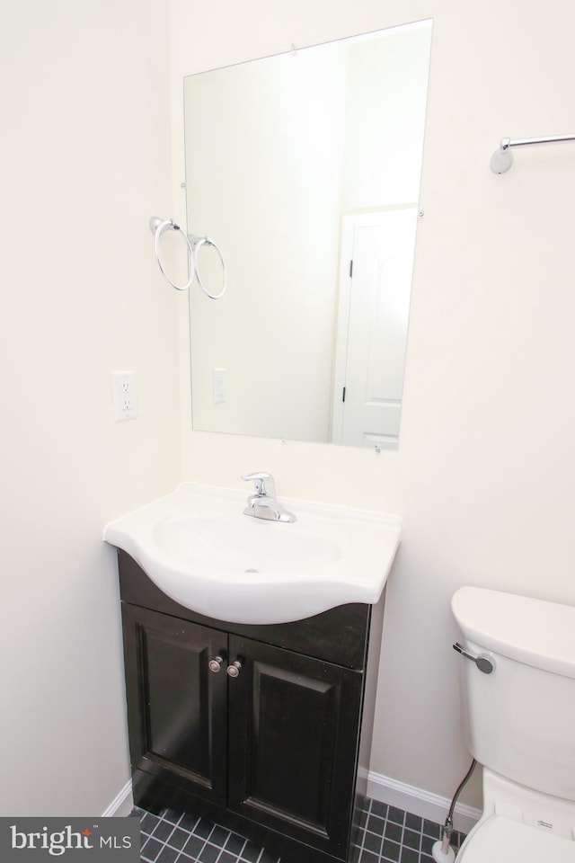 bathroom with toilet, tile patterned floors, and vanity