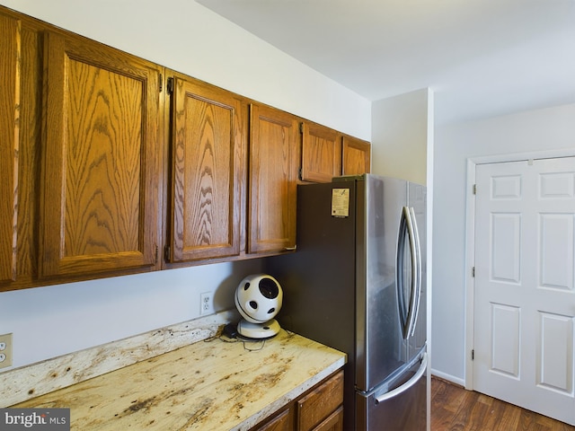 kitchen featuring stainless steel fridge and dark wood-type flooring