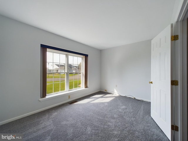 unfurnished room with dark carpet