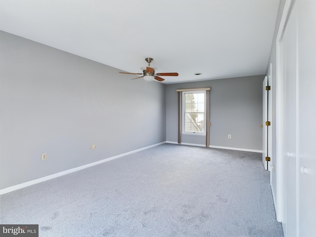 spare room with ceiling fan and light colored carpet