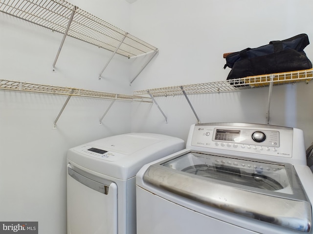 clothes washing area with washer and clothes dryer