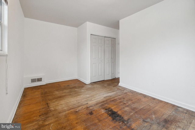 unfurnished bedroom featuring hardwood / wood-style flooring and a closet