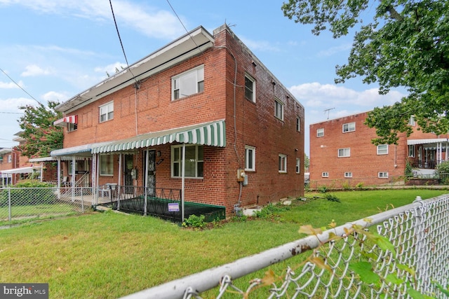 rear view of property featuring a yard