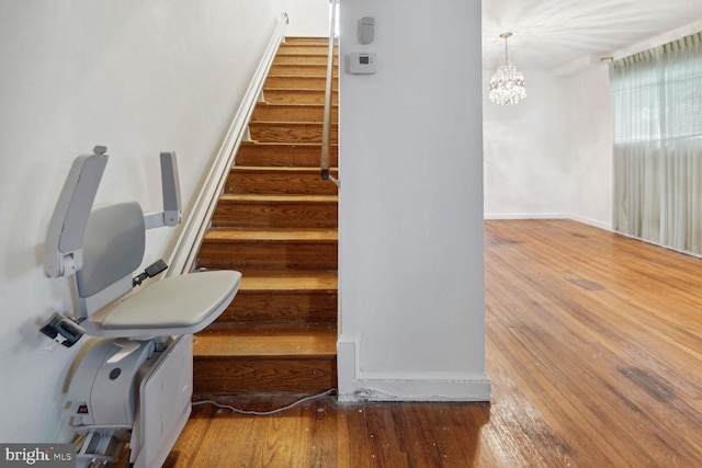 staircase featuring a notable chandelier and hardwood / wood-style floors