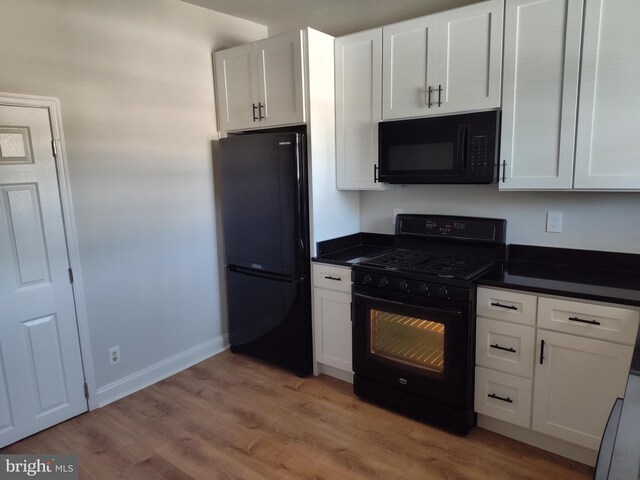 kitchen with white cabinetry, light hardwood / wood-style flooring, and black appliances