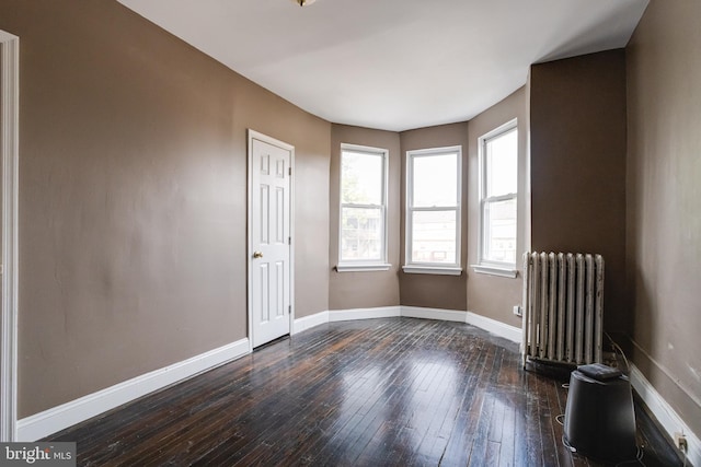 empty room with radiator and hardwood / wood-style flooring