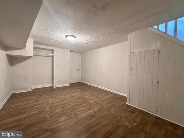 basement with dark hardwood / wood-style flooring and a textured ceiling