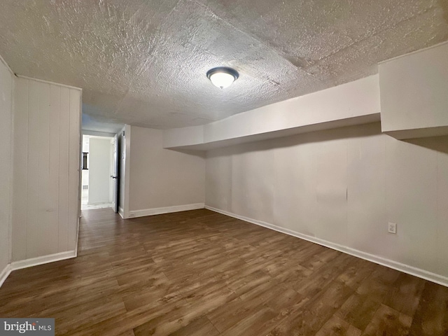 basement featuring dark hardwood / wood-style flooring and a textured ceiling