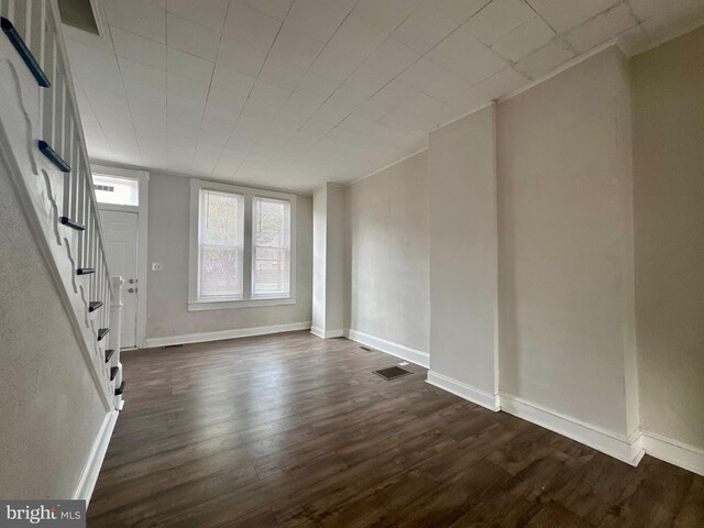 unfurnished room with dark wood-type flooring