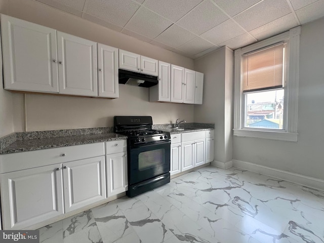 kitchen featuring white cabinetry, a drop ceiling, light tile patterned floors, sink, and black gas range oven