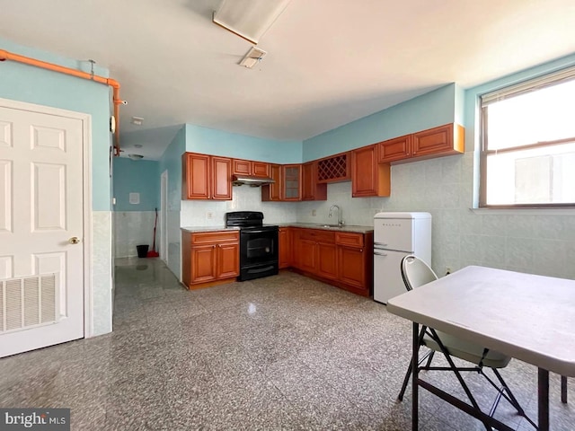 kitchen with white refrigerator and black / electric stove