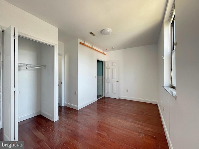 unfurnished bedroom featuring hardwood / wood-style floors and a closet