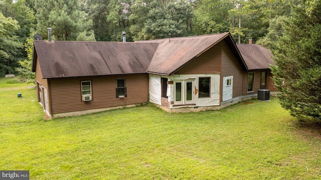 back of property featuring a yard and central air condition unit