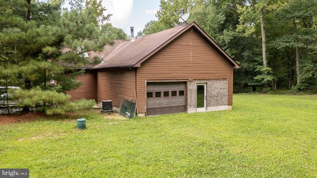 view of side of home with a garage, a yard, and cooling unit