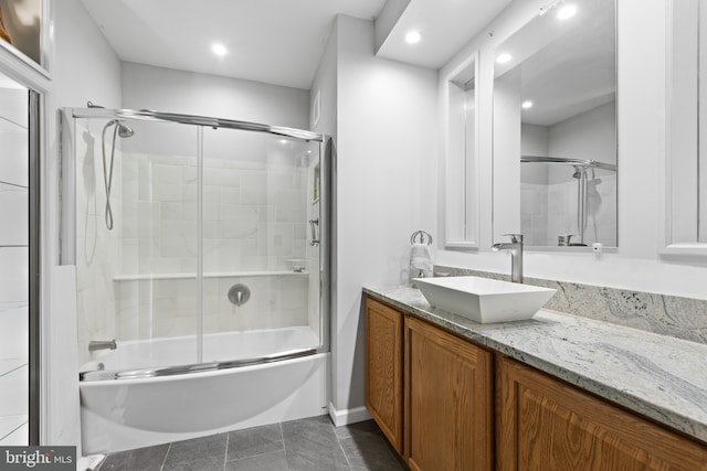 bathroom featuring tile patterned flooring, vanity, and combined bath / shower with glass door