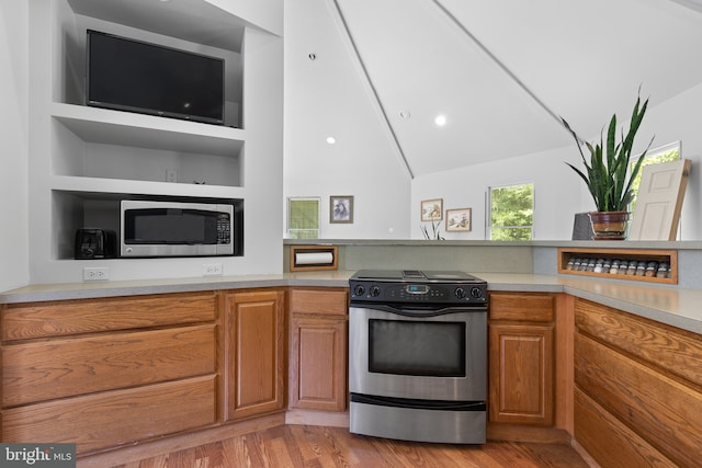 kitchen featuring high vaulted ceiling, stainless steel appliances, and light hardwood / wood-style floors