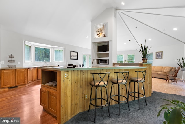 kitchen featuring a kitchen island, plenty of natural light, a breakfast bar area, and lofted ceiling