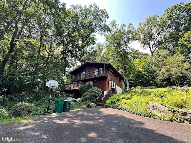 view of front of home with stairway, a deck, and driveway