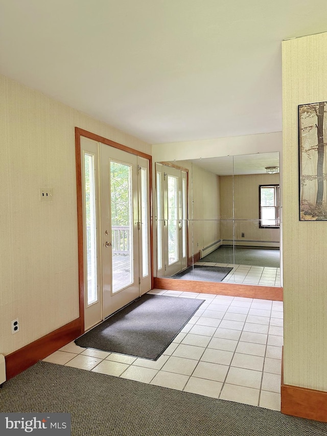 doorway to outside with a baseboard heating unit and light tile patterned floors
