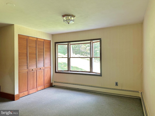 unfurnished bedroom with carpet floors, a closet, and a baseboard radiator