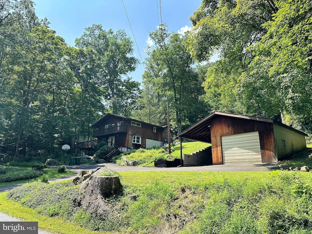 view of front of house featuring a garage, an outdoor structure, and driveway