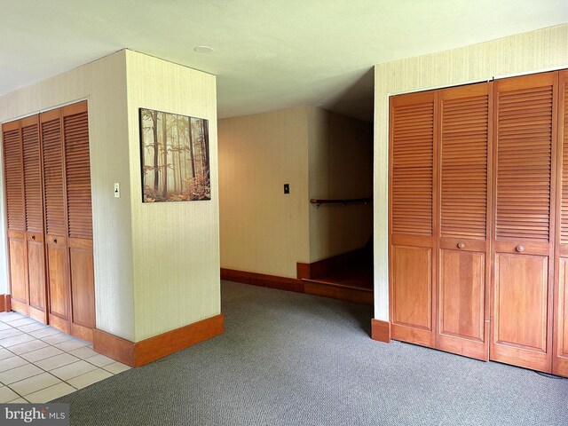 hallway featuring light carpet and baseboards