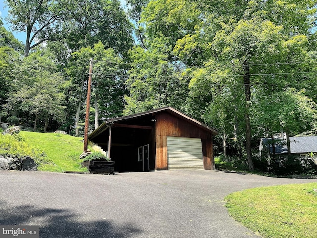 detached garage featuring asphalt driveway