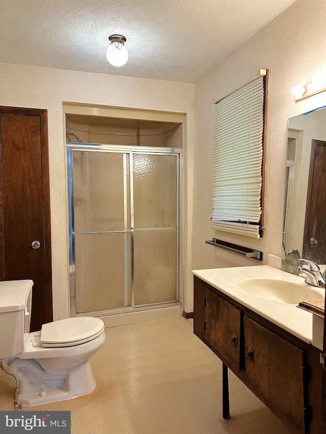 full bath with a stall shower, wallpapered walls, a textured ceiling, toilet, and vanity