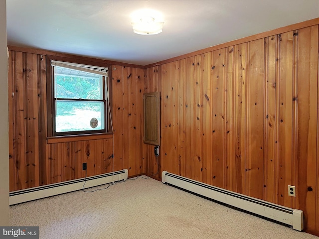 carpeted spare room with a baseboard heating unit and wooden walls