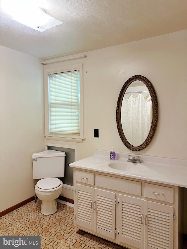 bathroom with vanity, a textured ceiling, and toilet