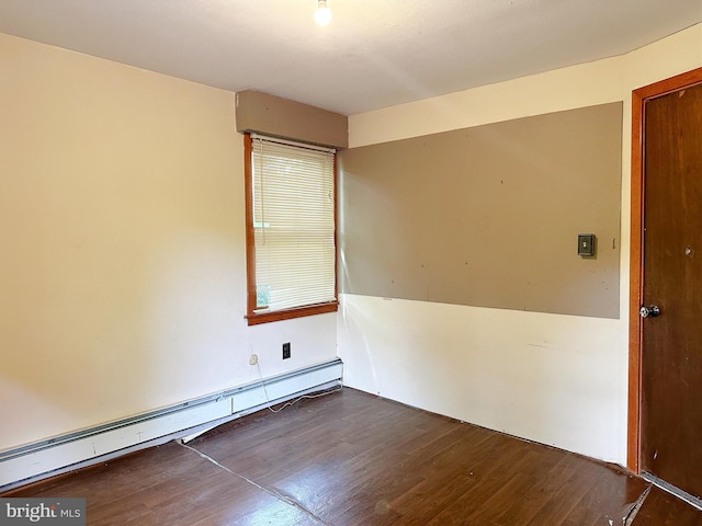 unfurnished room featuring dark wood-type flooring and a baseboard heating unit