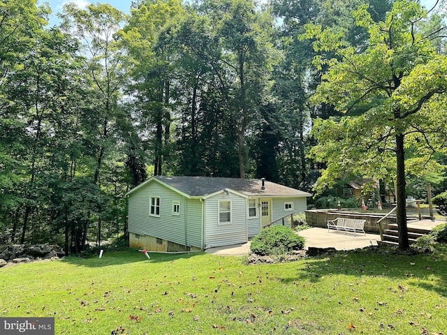 rear view of property with a wooden deck, a lawn, and crawl space