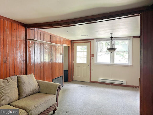 living room with a baseboard heating unit, carpet floors, and wood walls