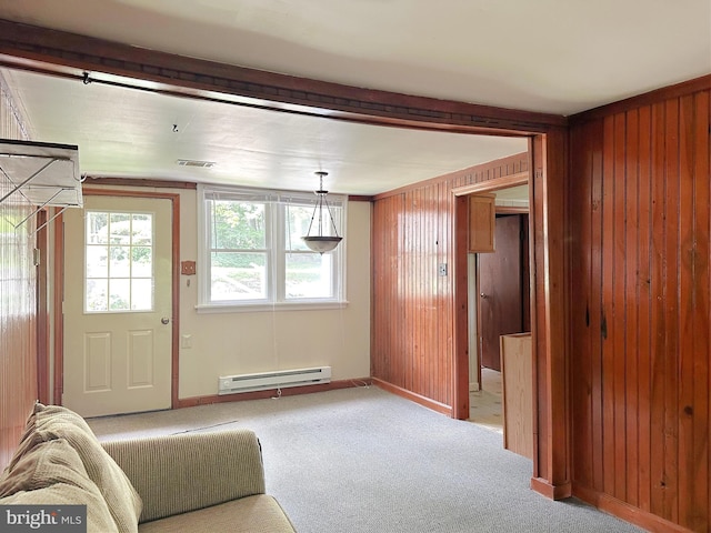 carpeted living room featuring wood walls, a baseboard radiator, and ornamental molding