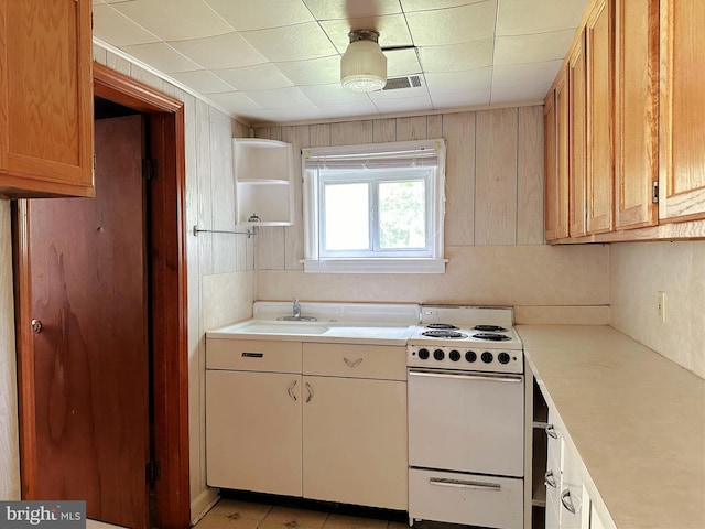 kitchen with white range with electric cooktop, light countertops, a sink, and open shelves