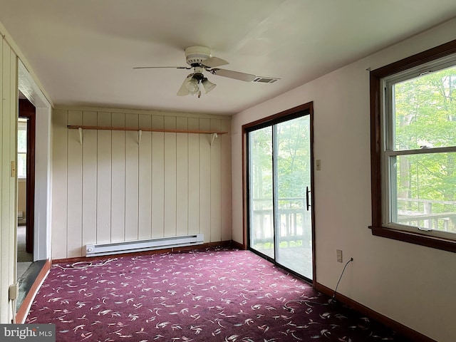 carpeted empty room featuring ceiling fan and a baseboard radiator