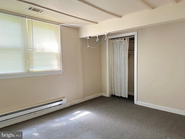 unfurnished bedroom with a baseboard radiator, dark carpet, a closet, and baseboards