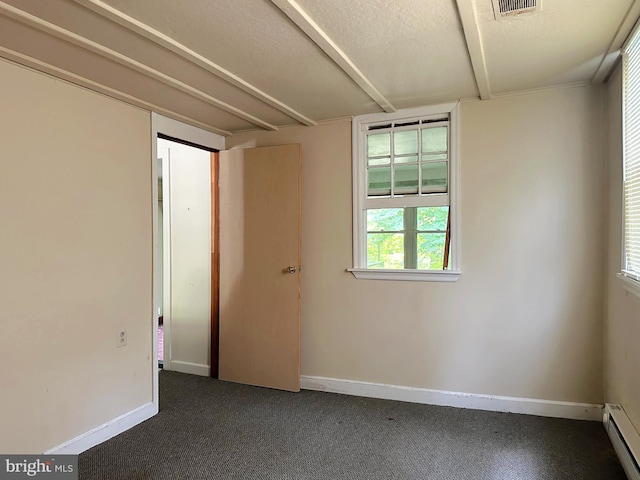 empty room with a baseboard radiator, a textured ceiling, and dark carpet