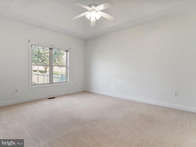 spare room featuring light carpet and ceiling fan