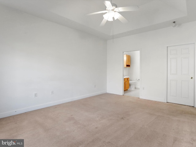 unfurnished bedroom featuring ceiling fan, light carpet, and connected bathroom