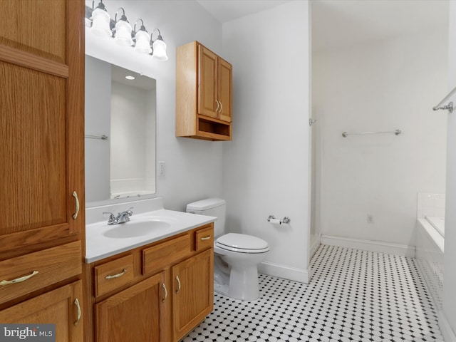 bathroom with tile patterned flooring, a bath, vanity, and toilet