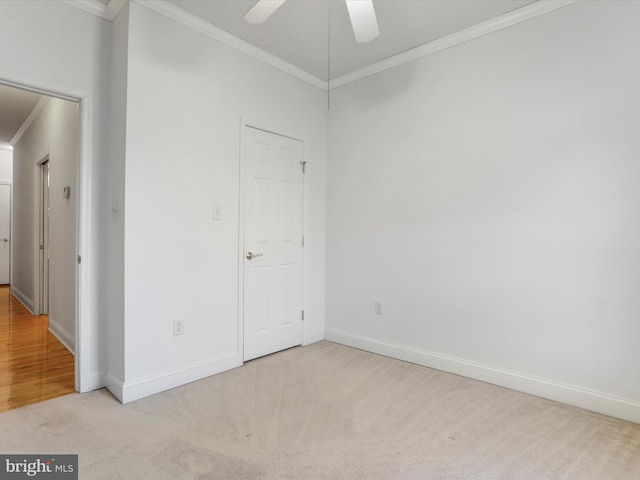 spare room with light colored carpet, ceiling fan, and crown molding