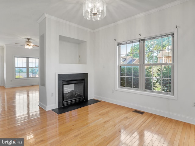 unfurnished living room with hardwood / wood-style flooring, ceiling fan with notable chandelier, and ornamental molding